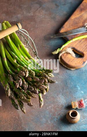 Ensemble de légumes d'asperges biologiques frais cultivés à la maison dans un panier prêt pour la cuisson de nourriture végétalienne saine sur un fond de pierre. Banque D'Images