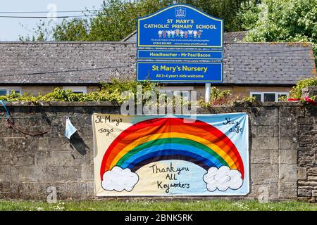 Un panneau « Merci à tous les travailleurs clés » arc-en-ciel qui a été accroché sur un mur d'école primaire est représenté en face de l'hôpital communautaire de Chippenham, Wiltshire. Banque D'Images