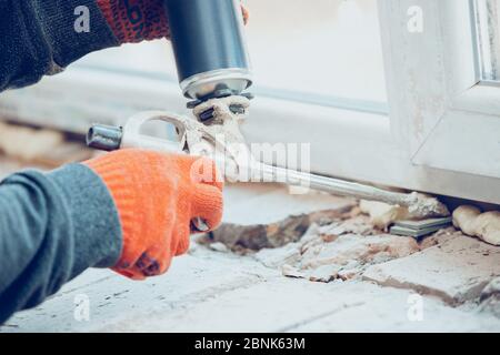 Gros plan du réparateur en uniforme, professionnel travaillant à l'aide d'équipements de construction. Processus de construction, rénovation d'appartements, réparation, construction. Sciage, raccordement, découpe, préparation. Banque D'Images