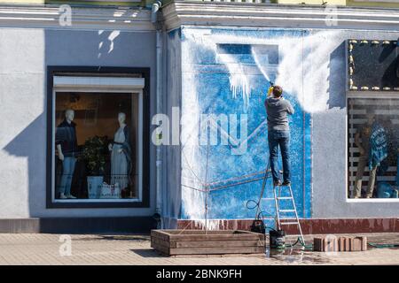 Un homme lave la façade et les fenêtres de magasin. Équipements modernes et produits de nettoyage pour le lavage et le nettoyage. Préparation du magasin pour l'ouverture. Banque D'Images