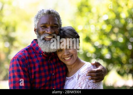 Portrait d'un couple de course mixte senior appréciant leur temps dans le jardin Banque D'Images