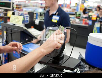 San Marcos, Texas, États-Unis, 2012: La consommation féminine fait glisser sa carte de crédit pour faire des achats au magasin Wal-Mart Supercenter. ©Marjorie Kamys COTER/Daemmrich photos Banque D'Images