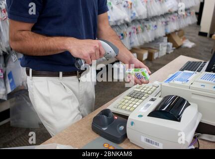 San Marcos, Texas, États-Unis, 2012 : un employé de sexe masculin utilise un lecteur portatif pour scanner le code-barres du produit à la pharmacie Wal-Mart Supercenter. ©Marjorie Kamys Cotera/Daemmrich Photographie Banque D'Images