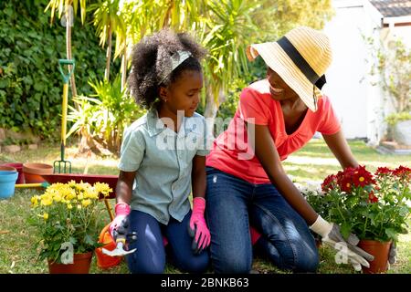 Fille afro-américaine et sa mère plantant des fleurs. Banque D'Images