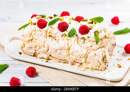 Gâteau à la meringue à la papillova avec crème et framboises. Meringue roulade, dessert d'été. Banque D'Images