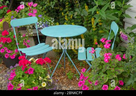 Chalet jardin avec la plantation de conteneurs et table et chaises bleu Banque D'Images