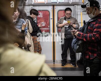 Tokyo, Japon - 10.11.19: Les gens attendent sur un train de banlieue très fréquenté Banque D'Images