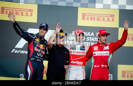 Austin Texas États-Unis, 18 novembre 2012 : le pilote gagnant Lewis Hamilton (c) se dresse entre le finisseur de deuxième place Sebastian Vettel (à l'extrême gauche), le pilote retraité Mario Andretti (l) et le finisseur de troisième place Fernando Alonso (r) sur le stand du gagnant lors de l'inauguration du Grand Prix des États-Unis de Formule 1 sur le circuit des Amériques (3,2 miles). ©Bob Daemmrich Banque D'Images