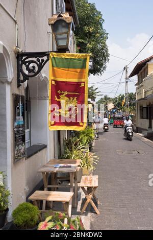 dh Sri Lankan drapeau lion GALLE FORT SRI LANKA à l'extérieur de café scooter de moteur dans les rues de personnes de rue Banque D'Images