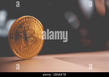 Gros plan de la brillante Golden Bitcoin Crypto monnaie Rolling sur la table en bois. Banque D'Images