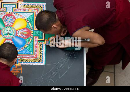 Austin, Texas États-Unis, 11 janvier 2013: Des moines bouddhistes tibétains du monastère de Drepung Loseling construisent un mandala de sable à grande échelle complexe et à motifs en utilisant des millions de grains de sable coloré à l'Université du Texas au musée d'art d'Austin Blanton Un mandala de sable est ritualistiquement détruit une fois qu'il a été achevé et ses cérémonies d'accompagnement et de visualisation sont terminées pour symboliser la croyance doctrinale bouddhiste dans la nature transitoire de la vie matérielle. Banque D'Images