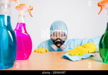 Portrait de l'homme bien rangé concentré désinfecter le bureau utiliser essuie-glace chiffon chimique bouteille porter blanc costume noismat jaune latex gants lunettes masque respiratoire isolé Banque D'Images