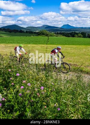 Vélo sur la piste près du village français de Phialeix. En arrière-plan : le Puy de Dôme (1465m), sommet volcanique du massif Central. Il appartient à la chaîne des Puys, la chaîne de montagne des puys, avec 80 volcans Banque D'Images