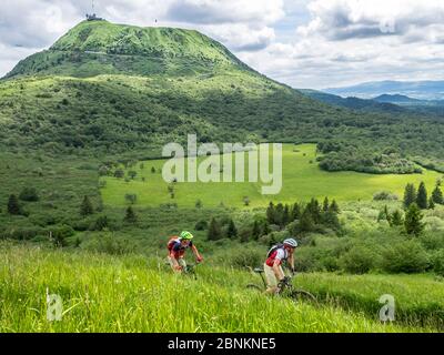 Piste de vélo de montagne unique au Puy Pariou (1209m). En arrière-plan, le Puy de Dôme (1465m), un pic volcanique du massif Central en France. Il fait partie de la chaîne des Puys, la chaîne de montagnes des Puys, avec 80 volcans. Banque D'Images