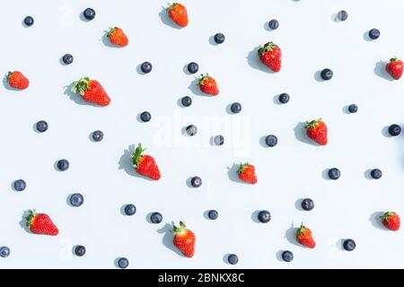 Motif de fruits colorés, bleuets et fraises sur fond bleu. Plan d'étapage avec vue de dessus. Banque D'Images