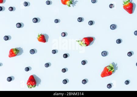 Motif de fruits colorés, bleuets et fraises sur fond bleu. Plan d'étapage avec vue de dessus. Banque D'Images