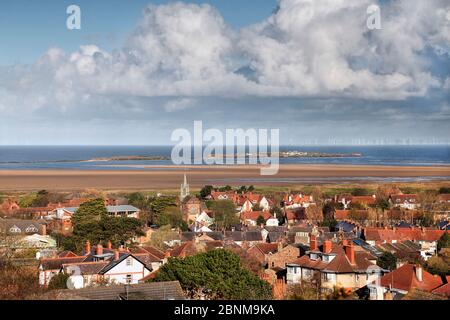 Hilbre Island et Little Hilbre dans l'estuaire de la Dee, vue sur les toits de West Kirby avec des éoliennes en arrière-plan Wirral, Royaume-Uni, avril. Banque D'Images