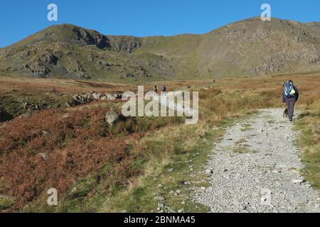 Marcheurs sur la route de Walna SCAR, un chemin restreint dans le parc national de Lake District, Cumbria, Angleterre. Banque D'Images