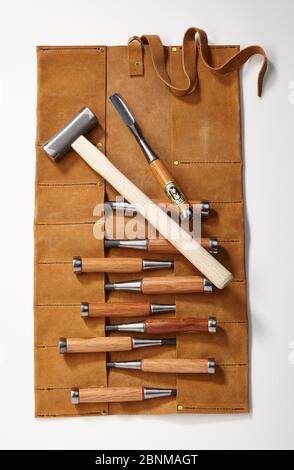 Un jeu de burins en bois avec une poche à roulettes en cuir et un marteau, photo sur blanc, série d'outils pour le travail du bois du Japon, outil japonais pour le travail du bois Banque D'Images