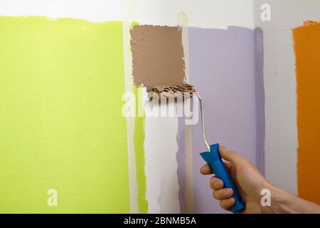 Bricolage mur design 01, étape par étape de production de bricolage, bandes verticales colorées dans la zone du mur inférieur, étape 06 peinture des zones scellées avec des autocollants muraux et rouleau de peinture Banque D'Images