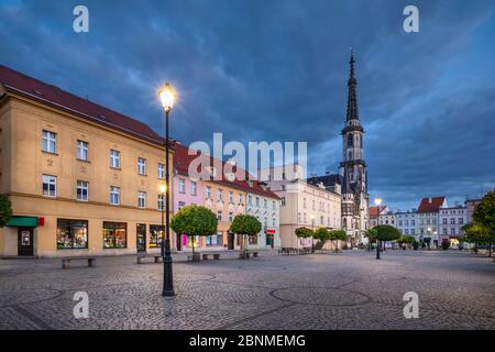 Zabkowice Slaskie, Pologne. Vue sur la place du marché au crépuscule avec les maisons anciennes et colorées et le bâtiment de l'hôtel de ville historique Banque D'Images