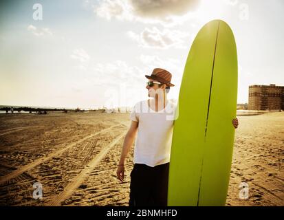 jeune homme sur la plage avec surf Banque D'Images