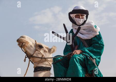 tuareg homme dans des vêtements traditionnels assis sur un chameau Banque D'Images