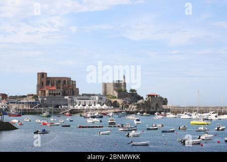 Vue sur le port à Castro Urdiales Cantabria Espagne avec église et des bâtiments en bord de mer Banque D'Images