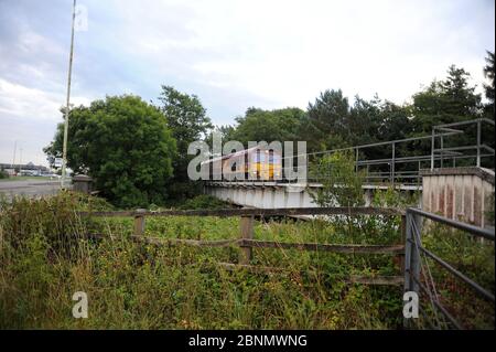 66204 et train traversant la rivière Ewenny peu de temps après avoir quitté l'usine Bridgend Ford. Banque D'Images