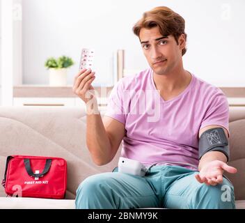 L'homme malade à la maison avec une trousse de premiers secours Banque D'Images