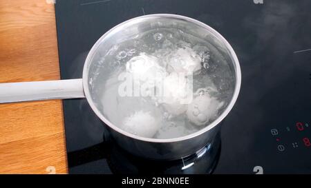 Les œufs de poulet sont cuits dans une casserole sur une lève électrique. Banque D'Images