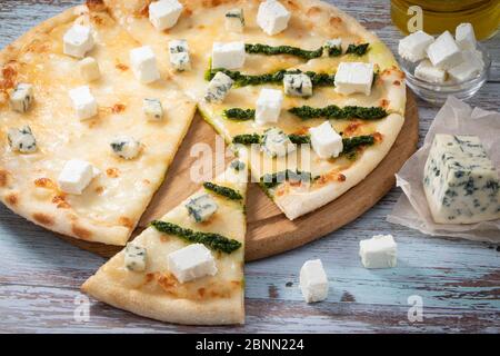 Pizza quatre fromages sur table en bois blanc. Banque D'Images