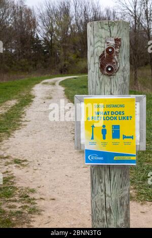 Washington Township, Michigan - UN panneau à un point de départ de Stony Creek Metropark rappelle aux randonneurs de rester la distance sociale correcte à l'écart pendant le c Banque D'Images