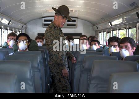 Instructeur de forage du corps des Marines des États-Unis, SSTGT. Fernando Nunez Martinez, accueille masque de visage portant des recrues comme ils arrivent en bus au corps de recrutement de Marine le 15 mai 2020 à San Diego, Californie. Banque D'Images