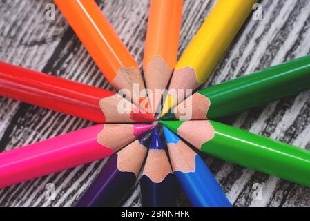 Crayons de couleur en ordre dans les couleurs de roue de couleur sur le fond en bois. Banque D'Images