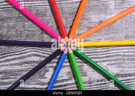 Crayons de couleur en ordre dans les couleurs de roue de couleur sur le fond en bois. Banque D'Images