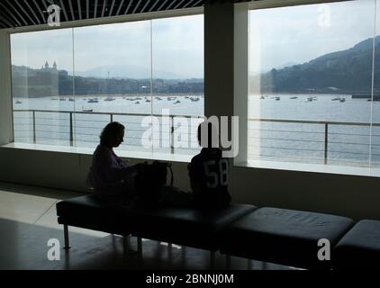 Vue sur la baie de San Sebastian Gipuzkoa pays basque Espagne de l'Aquarium à travers les fenêtres avec une femme et garçon relaxant silhoueté 2009 Banque D'Images