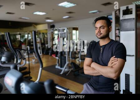 Jeune homme indien barbu faisant des exercices cardio à la salle de gym