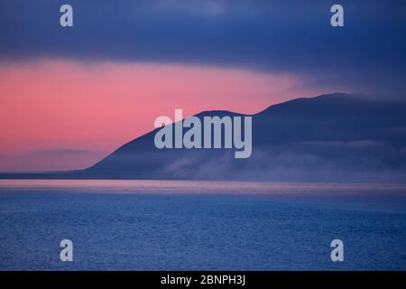 Brouillard nocturne sur Grundarfjoerdur en face des montagnes d'Eyrarfjall Banque D'Images