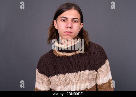 Jeune homme androgyne avec de longs cheveux prêts pour l'hiver Banque D'Images