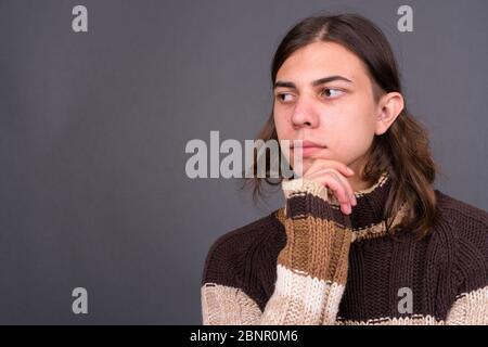 Jeune homme androgyne avec de longs cheveux prêts pour l'hiver Banque D'Images