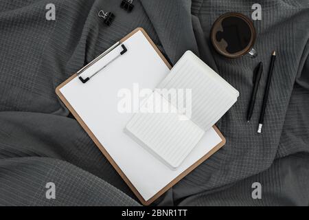 Tasse de café avec presse-papiers, agenda et stylo sur tissu écossais foncé. Flat lay, vue de dessus. Concept rester à la maison. Banque D'Images