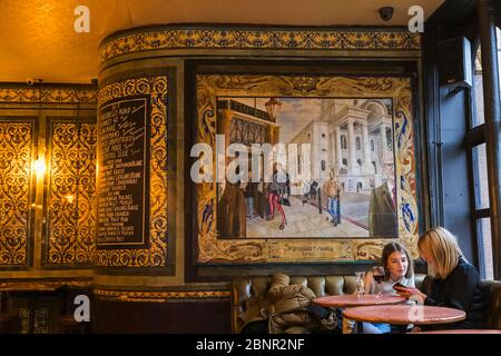 Angleterre, Londres, Shoreditch, Spitafields, The Ten Bells Pub, Deux Femmes Clientes Regardant Iphones Banque D'Images