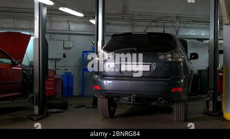 Deux voitures avec capot ouvert dans le service de réparation de voiture. Banque D'Images