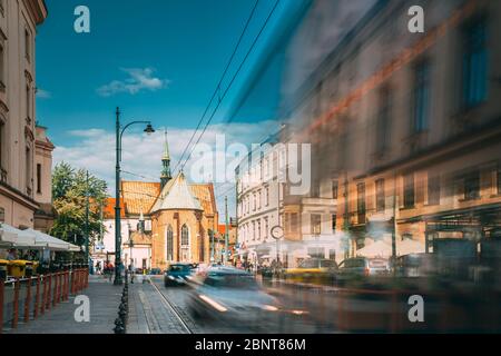 Cracovie, Pologne. Trams Motion près de la place dominicaine. Trafic et monastère franciscain et basilique Saint François d'Assise sur fond. Banque D'Images