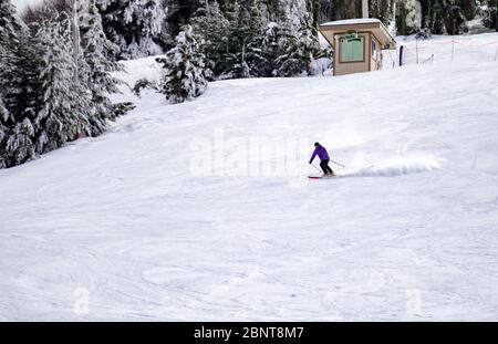 Ski sur toute la longueur sur neige poudreuse fraîche. Homme skieur descendant sur une pente ensoleillée des Alpes Banque D'Images