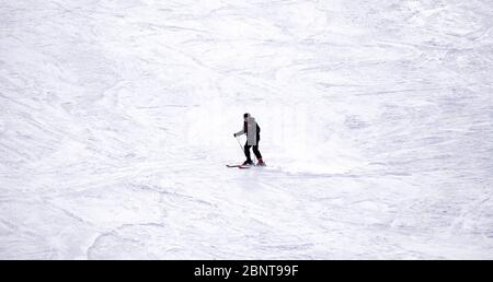 Ski sur toute la longueur sur neige poudreuse fraîche. Homme skieur descendant sur une pente ensoleillée des Alpes Banque D'Images