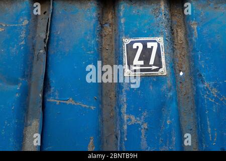 Ancienne plaque d'immatriculation rouillée. Numéro de maison sur un mur Banque D'Images