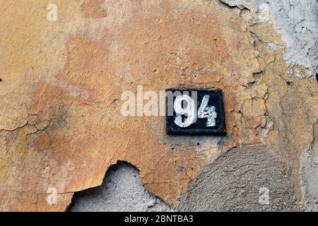 Ancienne plaque d'immatriculation rouillée. Numéro de maison sur un mur Banque D'Images