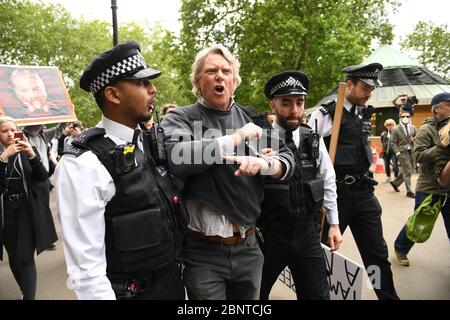 La police a menottant et a mis un manifestant à Hyde Park à Londres après l'introduction de mesures pour faire sortir le pays du confinement. Banque D'Images